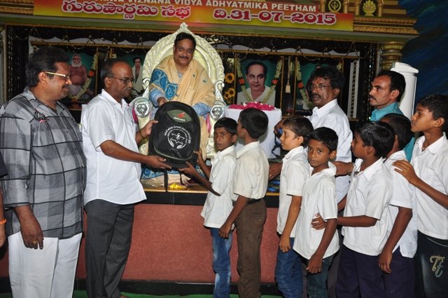Dr.Umar Alisha, UARDT chairman, ​distributing school bags to 125 students of R.R.BH.R BC boys hostel pithapuram on the occasion of Guru Pournami at Sri Viswa Vizanan Aadhyatmika Peetham new Ashram Premises